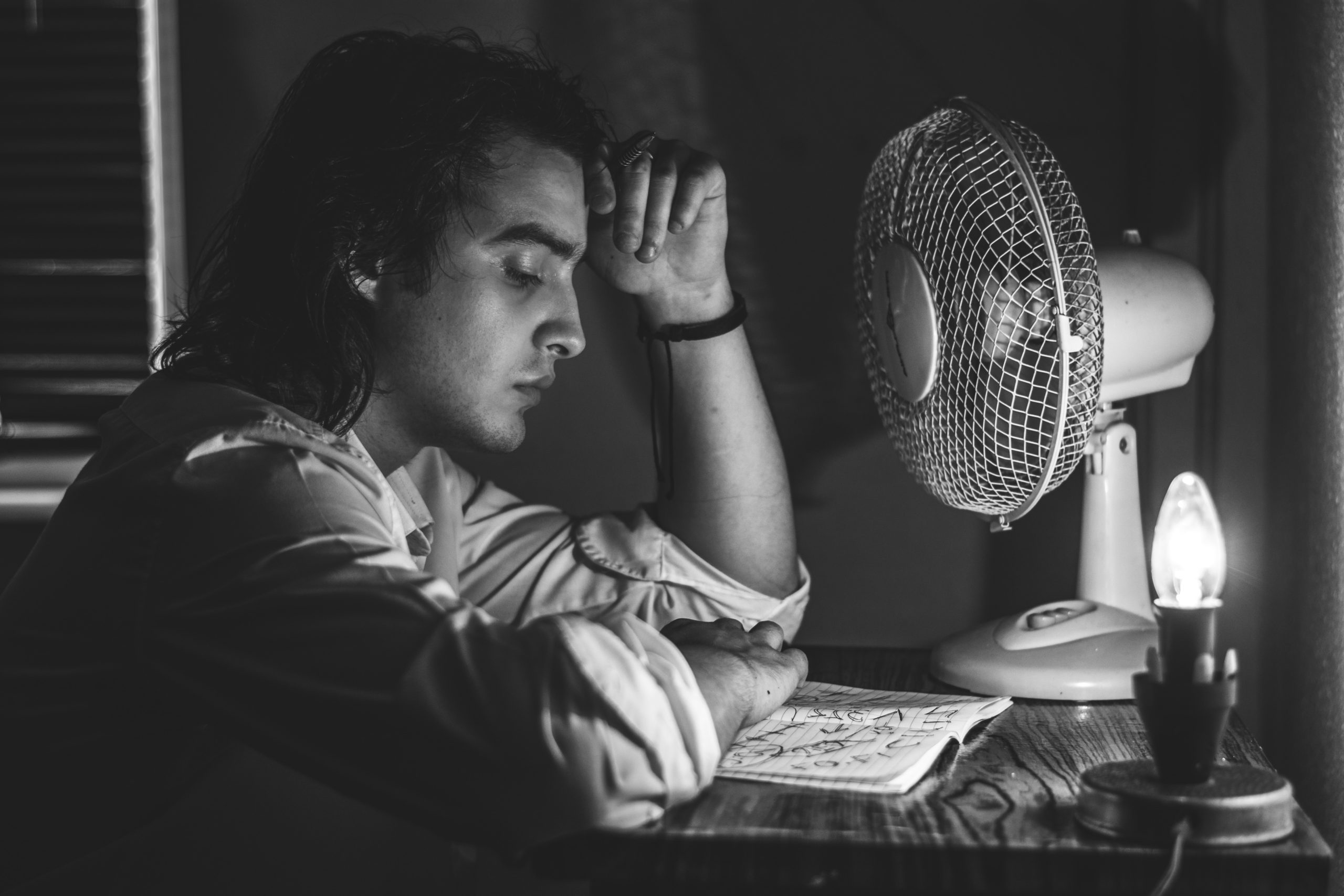 man in dress shirt sitting in front of table